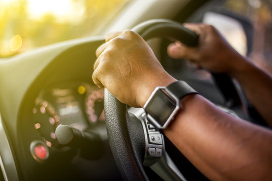 Man who wearing smart watch is driving vehicle while working or going to somewhere with the flare from the outside. - Powered by Adobe