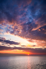 Naklejka na ściany i meble Sunset over calm sea in summer with sun beam, Europe