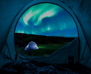 Illuminated tent and aurora in Iceland in summer at night