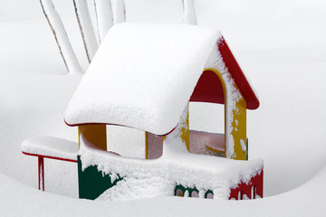 Small children's red-yellow-green house in kindergarten for children in winter landscape after snowfall. Russian Far East, Kamchatka Peninsula, Petropavlovsk-Kamchatsky City.