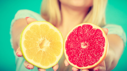 Woman holding red and green grapefruit