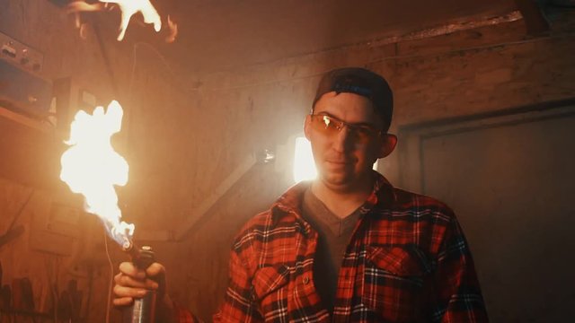 male mechanic in a garage with a gas burner in the hands slow mo