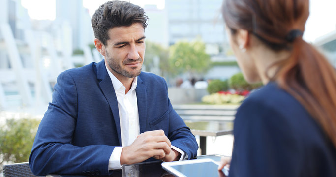 Business people discuss on project with digital tablet computer at outdoor cafe