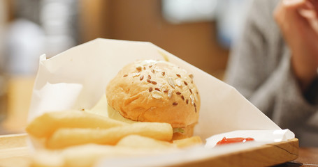 Eating french fries and burger in fast food restaurant