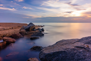 Long exposure of sea water channel to the ocean during sunset with beautiful clouds. 