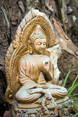 the statue of Buddha stands in a tropical forest