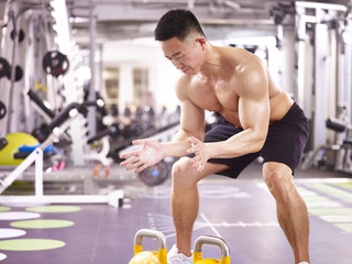 asian bodybuilder exercising in gym