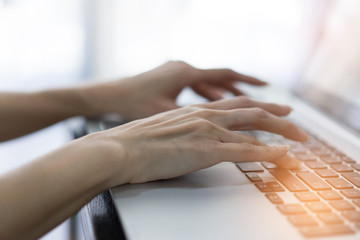 Obraz premium Working at home with laptop woman writing a blog. Female hands on the keyboard.blured background.