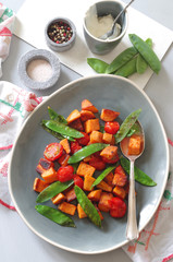 Süsskartoffelpfanne mit Zuckerschoten und Strauchtomaten