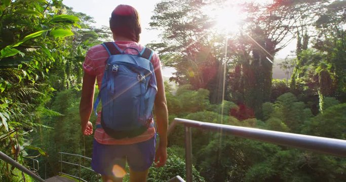 Woman hiking in Akaka falls State Park on Big Island, Hawaii. Female hiker visiting a popular tourist destination and hawaiian attraction. RED EPIC SLOW MOTION.