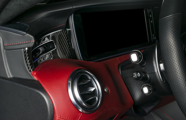 Fototapeta na wymiar AC Ventilation Deck in Luxury modern Car Interior. Modern car interior details with red and black leather with red stitching. Carbon panel. Perforated leather steering wheel