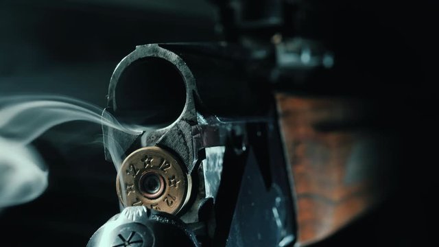 Smoking Barrel of rifle. Shotgun shells being removed from shotgun with smoke coming out. Macro, super close-up view. 4k.