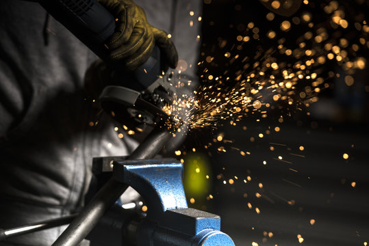 Close up of welder welding motorbike pipe in workshop