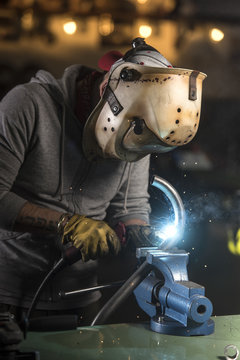 Professional mechanic welding motorbike pipe