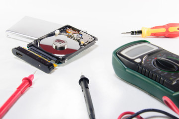 A broken hard disk with repairing and diagnostic tools.