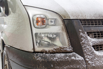 Snowy and dirty track headlight closeup. Truck in winter