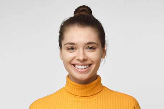 Close Up Portrait Of Smiling Pretty Girl In Yellow Sweater Isolated On Gray Background