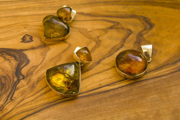 three pendants with blue amber on the wooden board