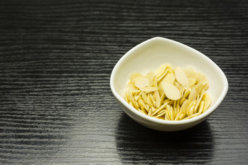 Almond flakes in a white bowl.