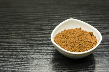 Cocoa powder in a bowl on the table.