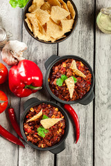 Bowls of hot chili con carne with ground beef, beans, tomatoes a