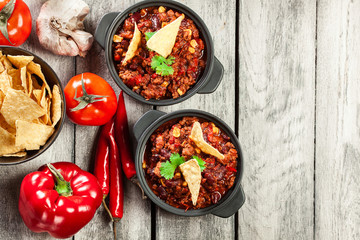 Bowls of hot chili con carne with ground beef, beans, tomatoes a