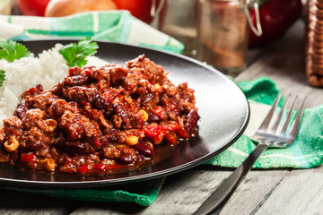 Hot chili con carne with ground beef, beans, tomatoes and corn served with rice