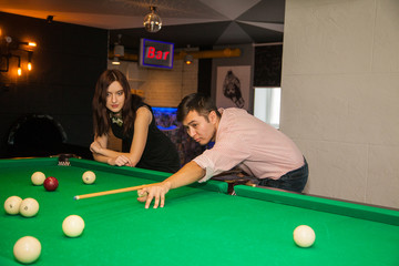 Fototapeta premium Friends at a party play billiards