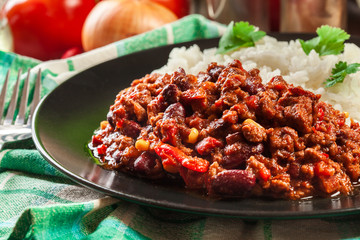 Hot chili con carne with ground beef, beans, tomatoes and corn served with rice