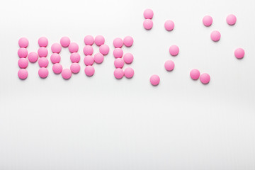 Inscription of hope pink pills on white background