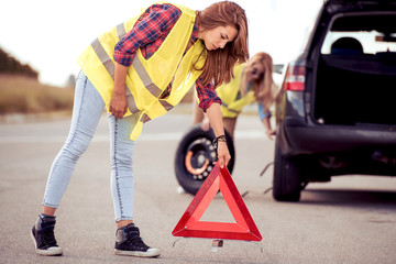 Two beautiful women having trouble with car.