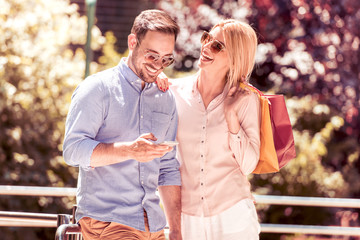 Couple taking a selfie after shopping outside.