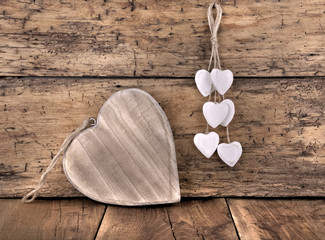 big wooden heart and white heats on rustic plank background