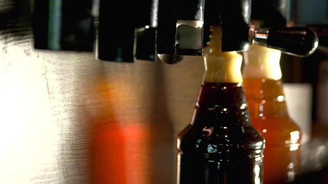 Barman removing beer bottles from beer taps. Close up barman hands removing plastic beer bottles.