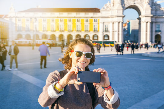 beautiful young woman tourist in lisbon doing photo on mobile phone. Travel, vacation, technology, Portugal is a popular destination for traveling in Europe