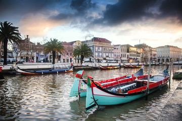 Fototapeta premium Beautiful cityscape. Bright boats on the pier in Aveiro, Portugal, at sunset