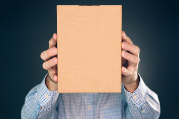 Man holding cardboard box package for mock up design