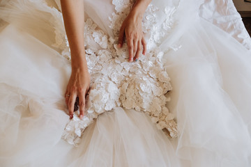 the bride touches her white wedding dress - obrazy, fototapety, plakaty