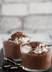 Chocolate mousse in a glasses on a black stone background.
