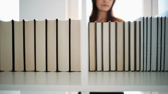 Woman finding book on a bookshelf