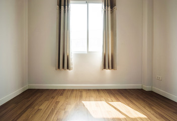 Interior space, empty room, laminate wooden floor with opened window receiving sunlight in the morning