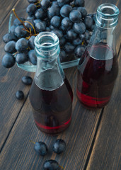 Dark fresh grape juice in glass bottles