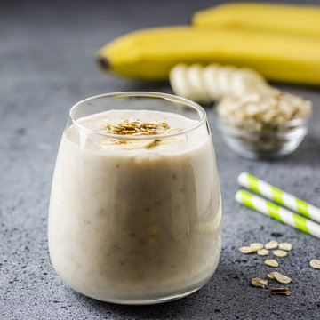 Peanut butter chocolate banana oat smoothie in glass on concrete background. Selective focus, space for text. 