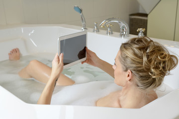 Frau mit digital tablet  in Badewanne