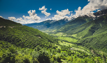 Plakat Panoramic summer landscape with green hill and mountain snow capped peak against blue cloudy sky. Svanetia region, Georgia. Main Caucasian ridge. Nature background. Holiday, hiking, travel, recreation