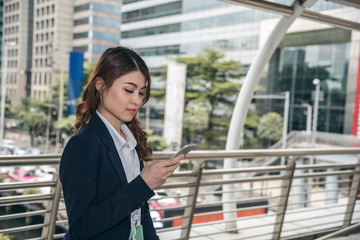Fototapeta premium Asian business woman is holding and using phone.