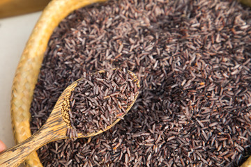 Organic Riceberry rice and wood spoon in weave basket, Food Background