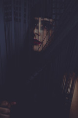 Nude brunette woman behind a curtain of black and thin threads with sensual look