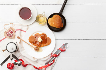 heart shaped pancakes on a light background. the concept of a festive breakfast for Valentine's Day or a pleasant surprise for a loved one