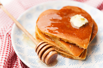 heart shaped pancakes on a light background. the concept of a festive breakfast for Valentine's Day or a pleasant surprise for a loved one
